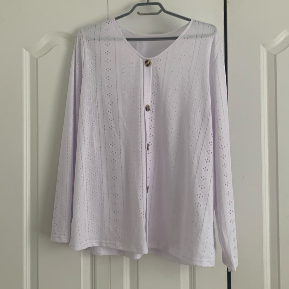White top with detailed lace look and decorative buttons.
